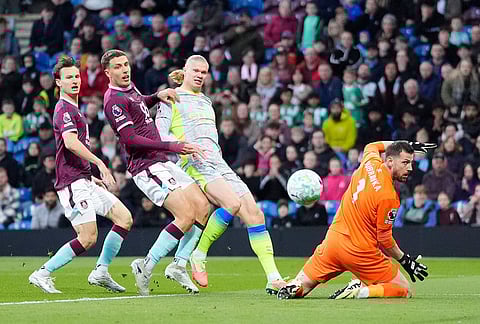 Manchester City's Erling Haaland, second right, scores his side's opening goal during the Premier League soccer match between Burnley and Manchester City in Burnley, England.