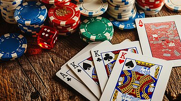 Poker chips, dice, and a winning hand of three Kings