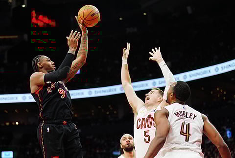 Toronto Raptors' RJ Barrett (9) shoots over Cleveland Cavaliers' Sam Merrill (5) and Evan Mobley (4) during the second half of an NBA playoff basketball game in Toronto.