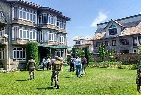 NIA personnel attach property belonging to Tafazul Hussain Parimoo, accused in a terror funding case, in Budgam, Jammu and Kashmir.