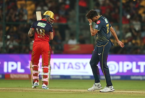Gujarat Titans' Mohammed Siraj reacts after a catch of Royal Challengers Bengaluru's Virat Kohli, ledt, was dropped during the Indian Premier League cricket match between Royal Challengers Bengaluru and Gujarat Titans in Bengaluru.
