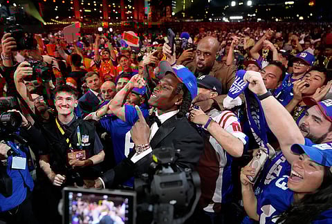 Ohio State linebacker Arvell Reese celebrates with fans after being chosen by the New York Giants with the fifth overall pick during the first round of the NFL football draft, in Pittsburgh. 