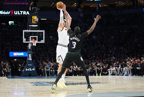 Denver Nuggets center Nikola Jokic (15) shoots over Minnesota Timberwolves forward Jaden McDaniels (3) during the first half in Game 3 of a first-round NBA basketball playoff series, in Minneapolis.