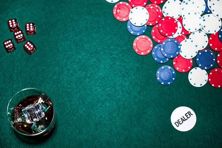 Poker chips, dice, and a drink on a green table - null