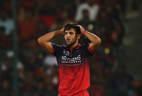 Royal Challengers Bengaluru's Rasikh Dar reacts after bowling a delivery during the Indian Premier League cricket match between Royal Challengers Bengaluru and Gujarat Titans in Bengaluru.