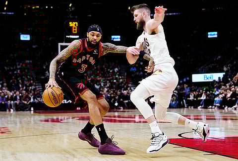 Toronto Raptors' Brandon Ingram (3) protects the ball from Cleveland Cavaliers' Dean Wade (32) during the second half of an NBA playoff basketball game in Toronto.