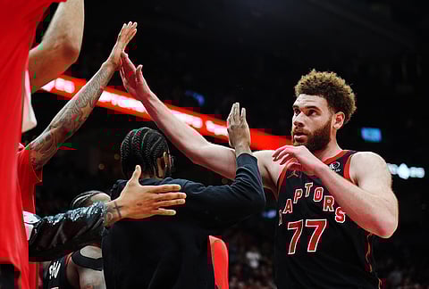 Toronto Raptors' Jamison Battle (77) is congratulated by teammates on the bench during  the second half of an NBA playoff basketball game in Toronto.