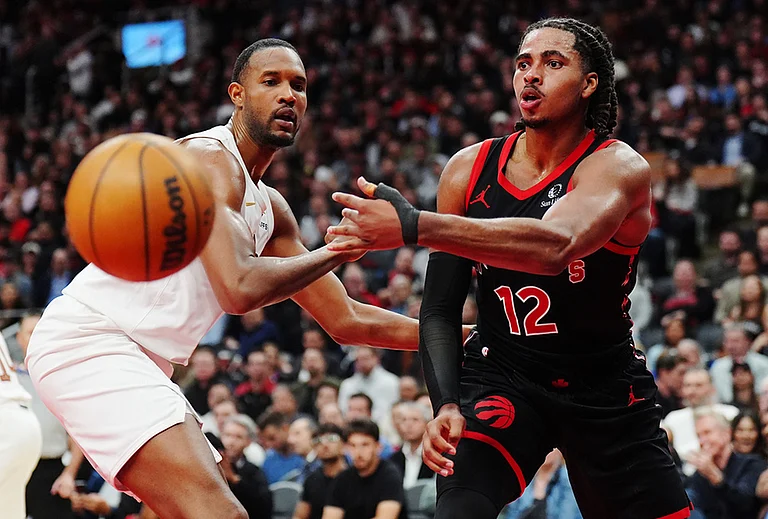 Toronto Raptors' Collin Murray-Boyles (12) passes around Cleveland Cavaliers' Evan Mobley (4) during the second half of an NBA basketball playoff game in Toronto. - | Photo: Frank Gunn/The Canadian Press via AP