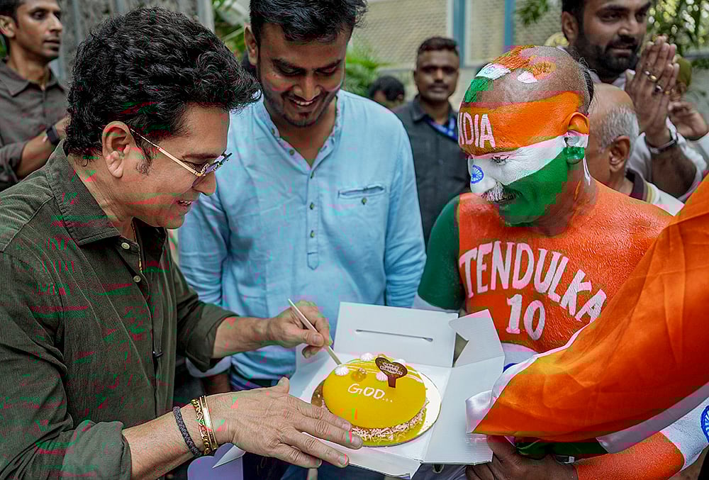 Mumbai: Cricketer Sachin Tendulkar celebrates his birthday with his fan Sudhir, right, at his residence, in Mumbai. - | Photo: AP/Kunal Patil