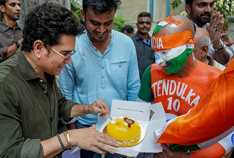 Mumbai: Cricketer Sachin Tendulkar celebrates his birthday with his fan Sudhir, right, at his residence, in Mumbai. - | Photo: AP/Kunal Patil