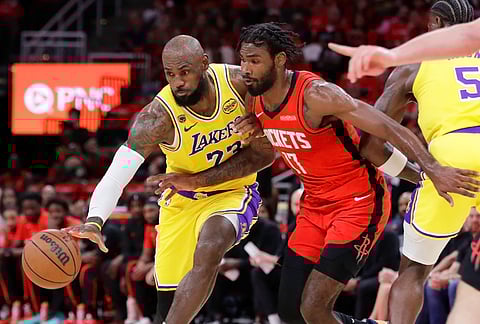 Los Angeles Lakers forward LeBron James, left, attempts to keep the ball as he drives around Houston Rockets forward Tari Eason during the first half in Game 3 of a first-round NBA playoffs basketball series in Houston.