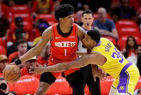 Houston Rockets guard Amen Thompson (1) looks to drive around Los Angeles Lakers guard Marcus Smart (36) who reaches in during the first half of Game 3 in a first-round NBA playoffs basketball series in Houston. 