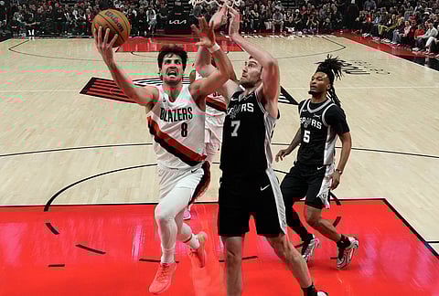 Portland Trail Blazers forward Deni Avdija (8) drives to the basket against San Antonio Spurs center Luke Kornet (7) during the second half in Game 3 of a first-round NBA playoffs basketball series in Portland, Oregon.