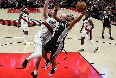 San Antonio Spurs forward Keldon Johnson (3) drives to the basket against Portland Trail Blazers center Donovan Clingan (23) during the second half in Game 3 of a first-round NBA playoffs basketball series in Portland, Oregon.