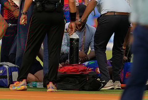 Physios attend to Delhi Capitals' Lungi Ngidi after he got injured while attempting a catch in the field during the Indian Premier League cricket match between Delhi Capitals and Punjab Kings in New Delhi.