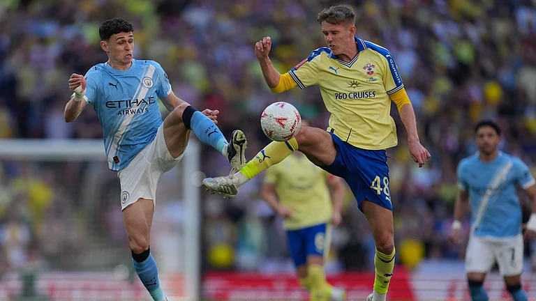 Manchester City's Phil Foden, left, and Southampton's Cam Bragg fight for the ball during the FA Cup semifinal soccer match between Manchester City and Southampton in Manchester, England, Saturday, April 25, 2026. - | Photo: AP/Kin Cheung