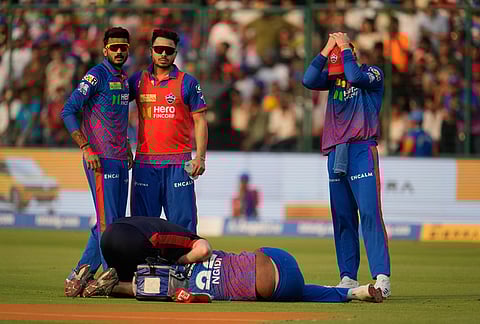 A physio attends to Delhi Capitals' Lungi Ngidi as he lies on the ground after he getting injured during the Indian Premier League cricket match between Delhi Capitals and Punjab Kings in New Delhi.