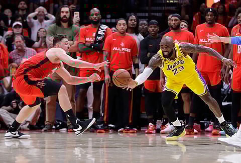 Los Angeles Lakers forward LeBron James (23) tips the ball inbounds in front of Houston Rockets center Alperen Sengun, left, during the second half of Game 3 in a first-round NBA playoffs basketball series in Houston.
