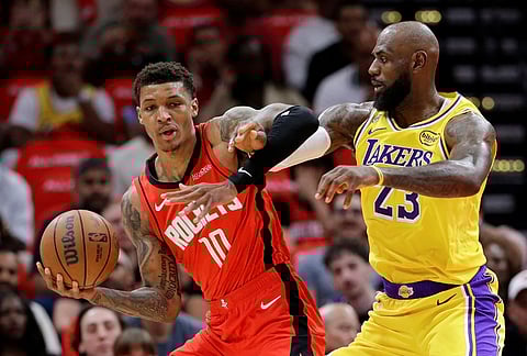 Houston Rockets forward Jabari Smith Jr. (10) becomes entangled with Los Angeles Lakers forward LeBron James (23) as he drives to the basket during the first half of Game 3 in a first-round NBA playoffs basketball series in Houston. 