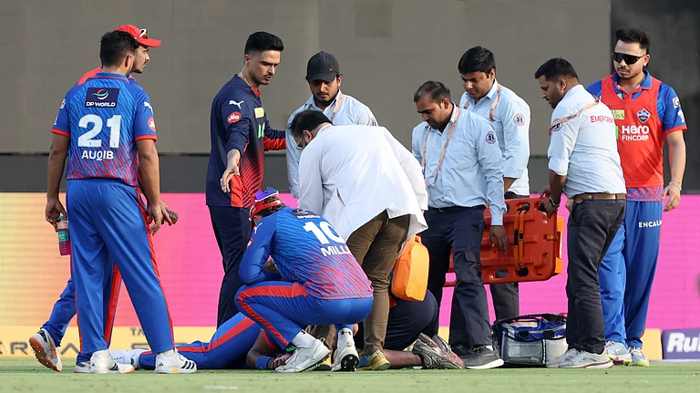 Lungi Ngidi receiving treatment inside the field after suffering head injury during the DC vs PBKS match while taking a catch. - IPL/X