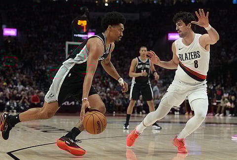 San Antonio Spurs guard Dylan Harper (2) drives against Portland Trail Blazers forward Deni Avdija (8) during the second half in Game 3 of a first-round NBA playoffs basketball series in Portland, Oregon.
