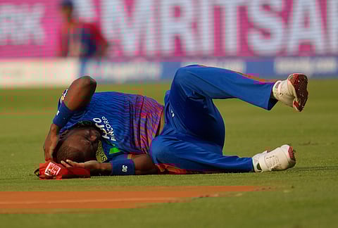 Delhi Capitals' Lungi Ngidi writhes in pain on the ground after attempting to take a catch during the Indian Premier League cricket match between Delhi Capitals and Punjab Kings in New Delhi.