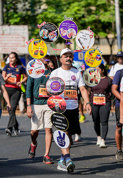 A man displays messages on cancer awareness while taking part in the TCS World 10K marathon, in Bengaluru.