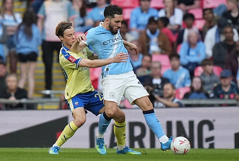 Southampton's Caspar Jander, left, and Manchester City's Rayan Cherki fight for the ball during the FA Cup semifinal soccer match between Manchester City and Southampton in Manchester, England.