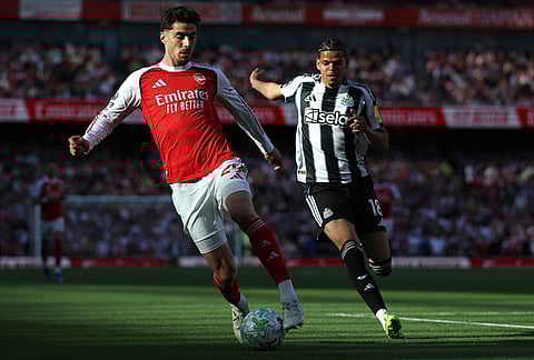 Arsenal's Kai Havertz, left, and Newcastle's William Osula challenge for the ball during the English Premier League soccer match between Arsenal and Newcastle United in London.