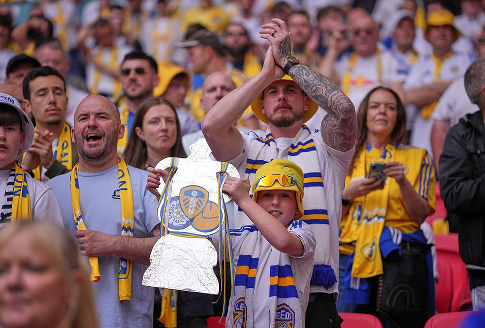 A Leeds fan holds a cutout of FA Cup trophy before the FA Cup semifinal soccer match between Chelsea and Leeds in London, England. - | Photo: AP/Kin Cheung