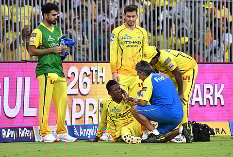 Chennai Super Kings' Akeal Hosein is attended to by a physio after he hurt himself while fielding during the Indian Premier League cricket match between Chennai Super Kings and Gujarat Titans in Chennai.