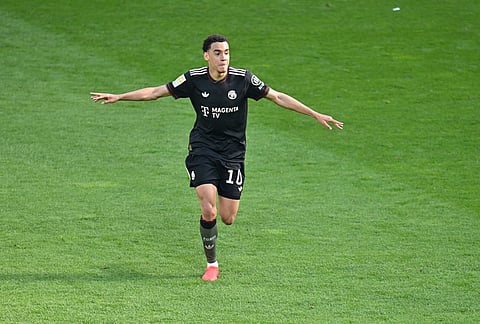 Bayern's Jamal Musiala celebrates after scoring his side's third goal during the Bundesliga soccer match between FSV Mainz 05 and FC Bayern Munich in Mainz, Germany.