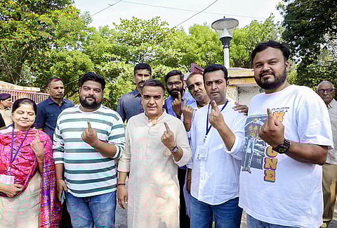 Gujarat Deputy Chief Minister Harsh Sanghavi shows his ink-marked finger after casting a vote in the municipal corporation elections in Surat. 