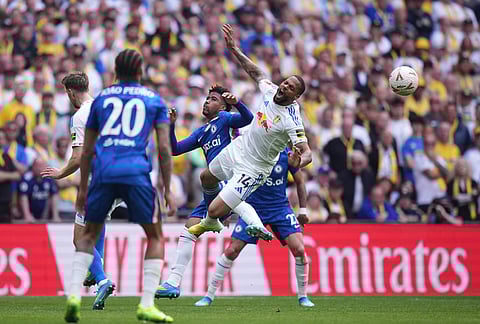 Chelsea's Andrey Santos and Leeds' Lukas Nmecha, right, collide during the FA Cup semifinal soccer match between Chelsea and Leeds in London, England.