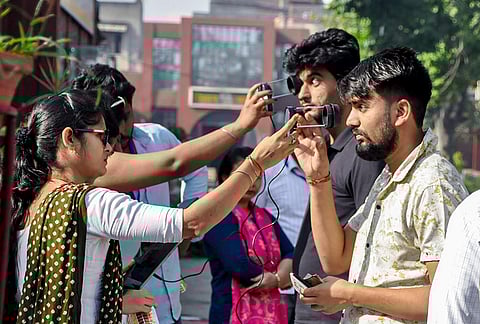 Aspirants undergo a security check before appearing for UP Police Home Guard examination, in Meerut.