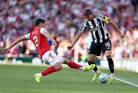Newcastle's William Osula, right, and Arsenal's William Saliba challenge for the ball during the English Premier League soccer match between Arsenal and Newcastle United in London.