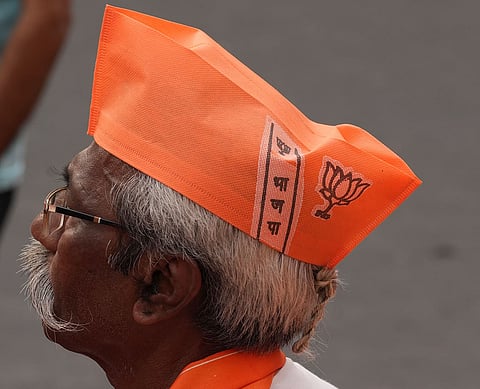 A BJP supporter is seen wearing a saffron cap during Modi's roadshow in Kolkata.