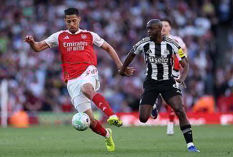 Arsenal's William Saliba, left, and Newcastle's Yoane Wissa challenge for the ball during the English Premier League soccer match between Arsenal and Newcastle United in London.