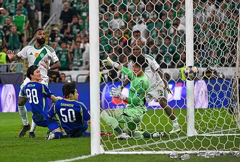 Al-Ahli's Feras Albrikan, left, scores at Machida Zelvia's goal keeper Kosei Tani, during the AFC Champions League Elite Final soccer match between Al-Ahli and Machida Zelvia at King Abdullah Sports City Stadium, in Jeddah, Saudi Arabia.