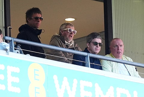 Liam Gallagher, left, and Noel Gallagher, second right, attend the FA Cup semifinal soccer match between Manchester City and Southampton in Manchester, England.