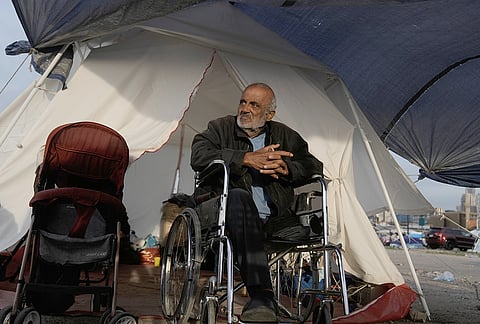 Mohammed Saeedoun, who fled Israeli airstrikes in Dahiyeh, Beirut's southern suburbs, sits in a wheelchair outside his shelter tent in Beirut, Lebanon, Friday, April 24, 2026. 