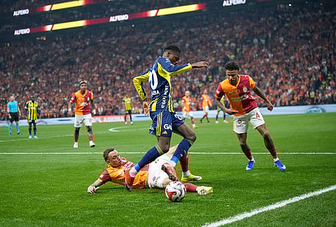 Fenerbahce's Anthony Musaba, top, vies for the ball with Galatasaray's Noa Lang during a Turkish Super Lig soccer match between Galatasaray and Fenerbahce in Istanbul, Turkey.
