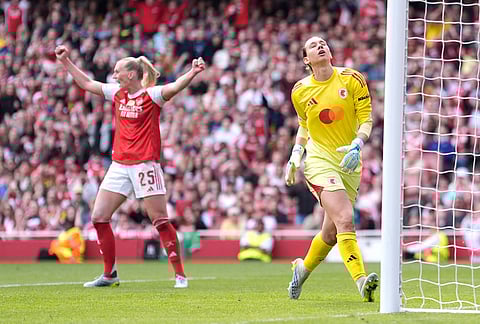 OL Lyonnes' goalkeeper Christiane Endler, right, reacts as Arsenal's Stina Blackstenius, left, celebrates her side's first goal during the Women's Champions League semi-final, first leg soccer match between Arsenal and OL Lyonnes in London, England.