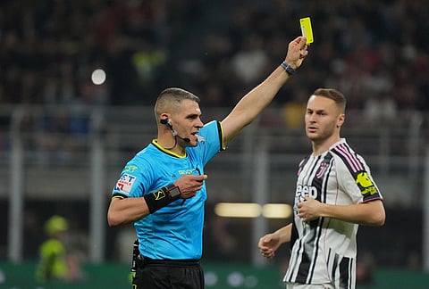 Referee Simone Sozza shows the yellow card during the Serie A soccer match between AC Milan and Juventus, in Milan, Italy.
