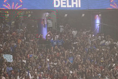 Crowd clicks photographs amid a dust storm during the Indian Premier League (IPL) T20 cricket match between Delhi Capitals and Royal Challengers Bengaluru, in New Delhi.