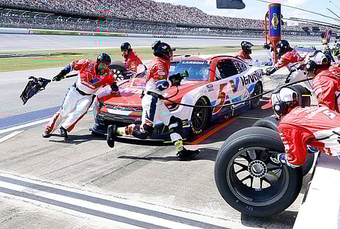 Kyle Larson's (5) pit crew changes tires during a NASCAR Cup Series auto race, in Talladega, Alabama.