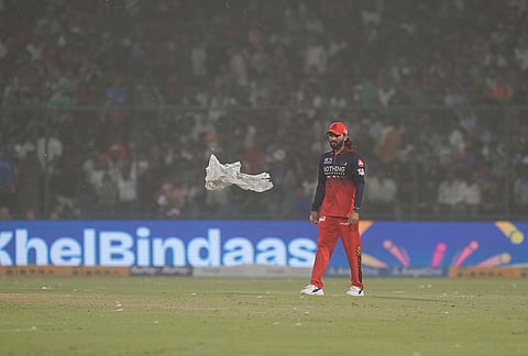 Royal Challengers Bengaluru's captain Rajat Patidar reacts amid a dust storm during the Indian Premier League (IPL) T20 cricket match between Delhi Capitals and Royal Challengers Bengaluru, in New Delhi.
