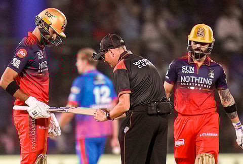 Royal Challengers Bengaluru's Devdutt Padikkal gets his bat checked by an umpire during the Indian Premier League (IPL) T20 cricket match between Delhi Capitals and Royal Challengers Bengaluru, in New Delhi.