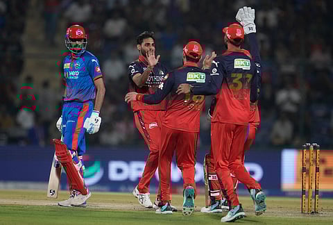 Royal Challengers Bengaluru's Bhuvneshwar Kumar, second left, celebrate with teammates the wicket of Delhi Capitals' captain Axar Patel, left, during the Indian Premier League cricket match between Delhi Capitals and Royal Challengers Bengaluru in Delhi.
