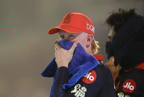 Royal Challengers Bengaluru's Jordan Cox reacts amid a dust storm during the Indian Premier League (IPL) T20 cricket match between Delhi Capitals and Royal Challengers Bengaluru, in New Delhi.